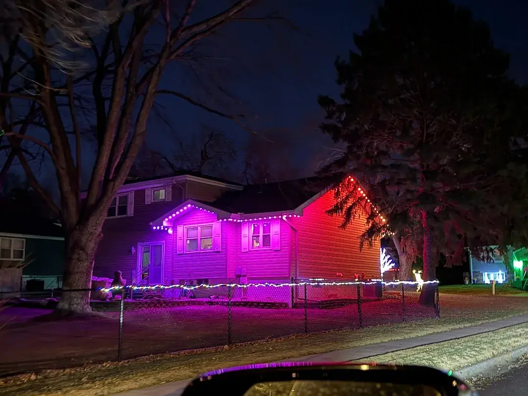 Permanent lighting in pink and red on a home at dusk
